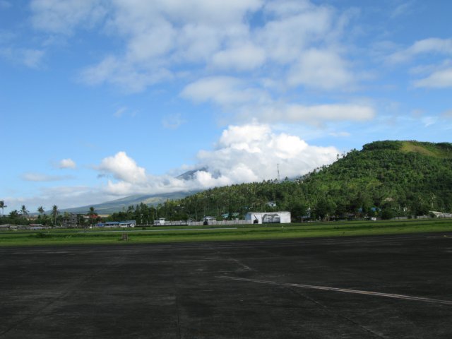 Filip195.JPG - Mayon Vulkanen bakom en massa moln som vanligt, sedd över startbanan på Legaspi flygplats, ett under av säkerhet där det gick folk 5meter från start/landningsbana och planterade ris